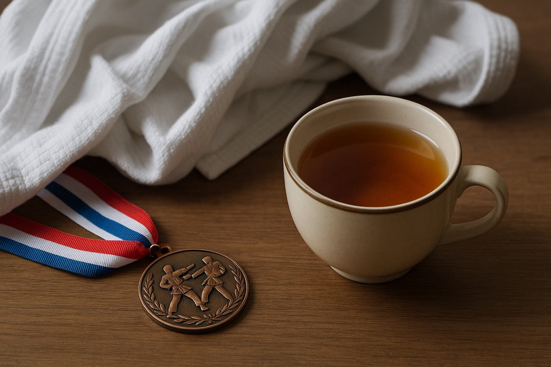A cup of tea beside a karate tournament medal and a rumpled gi.