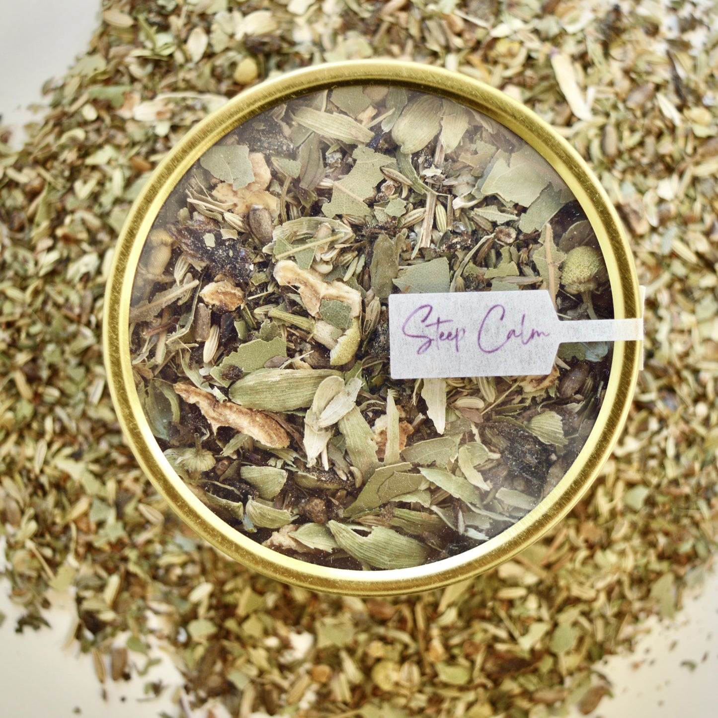 After dinner delight Herbal Tea 30 cups of tea size gold finish tin sitting on loose leaf tea that contains Fennel seed*, milk thistle seed*, green cardamom*, bay leaf*, lemon*, lemon balm*, peppermint*, chamomile*.