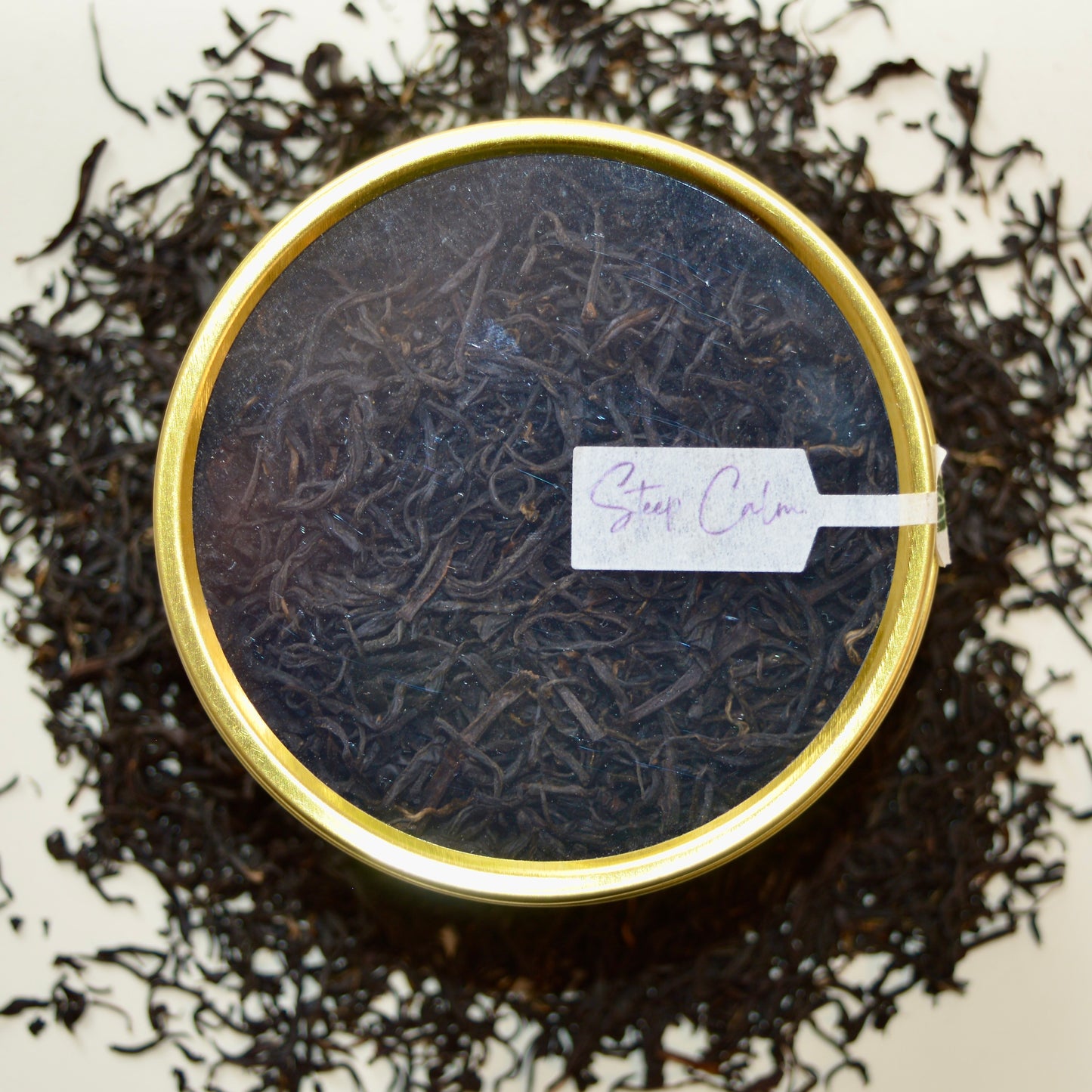 Imperial Keemun Mao Feng top view Black Tea 30 cups of tea size gold finish tin sitting on loose leaf tea that contains Chinese black tea (Certified organic)