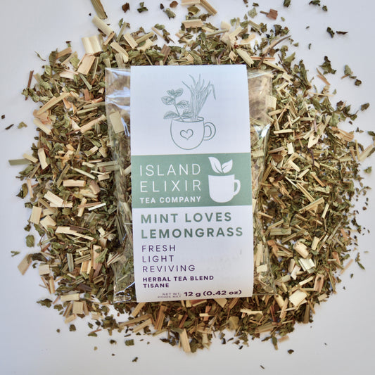 Mint loves lemongrass Herbal Tea 10 cups of tea size compostable packaging sitting on loose leaf tea that contains Lemongrass, peppermint, spearmint, lemon verbena