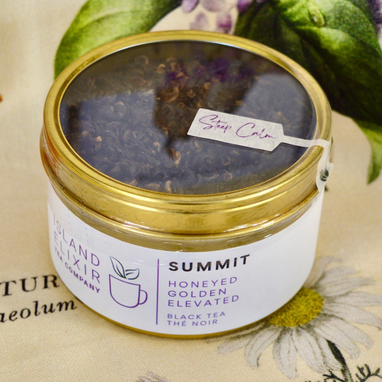 Summit Black Tea 30 cups of tea size gold finish tin sitting on loose leaf tea that contains Nepalese black tea