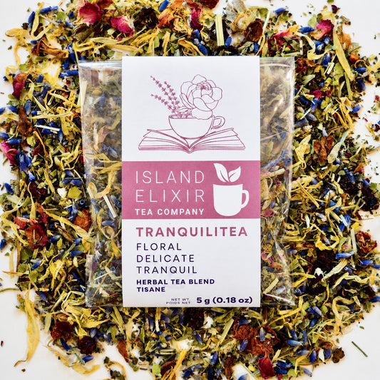 Tranquilitea Herbal Tea 4 cups of tea size compostable packaging sitting on loose leaf tea that contains Rose hip*, Lemon balm*, Lavender**, Oatstraw*, Marshmallow leaf*, Calendula*, Rose petals*.