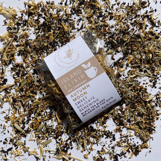 Tea package from Island Elixir Tea Company Autumn Moon black tea blend in 'Discover' size surrounded by scattered tea