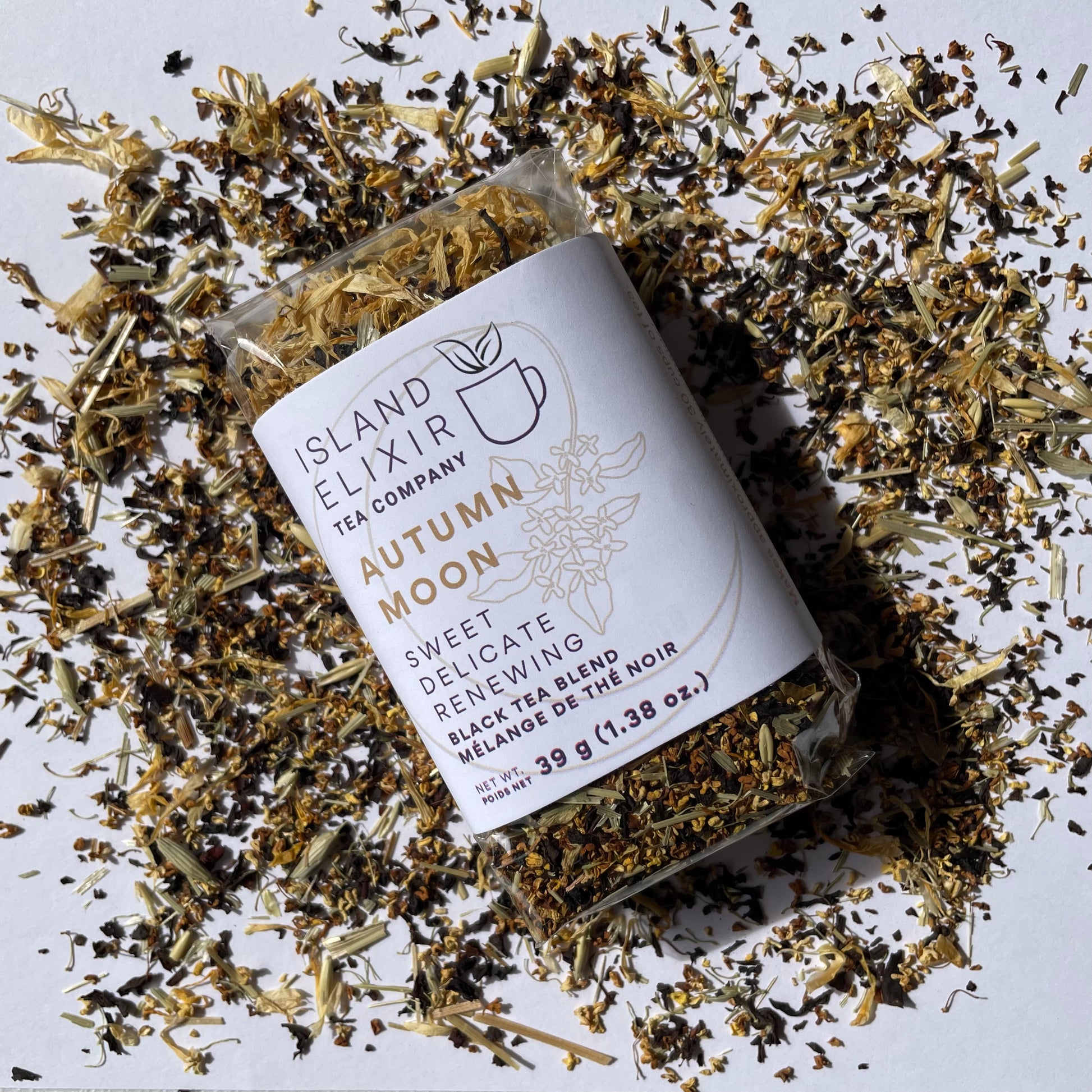 Tea package from Island Elixir Tea Company Autumn Moon black tea blend in 'Essential' size surrounded by scattered tea