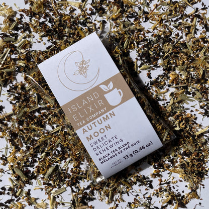 Tea package from Island Elixir Tea Company Autumn Moon black tea blend in 'Savour' size surrounded by scattered tea