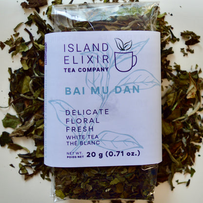 Bai Mu Dan White Tea 30 cups of tea size compostable packaging sitting on loose leaf tea that contains Chinese White Tea