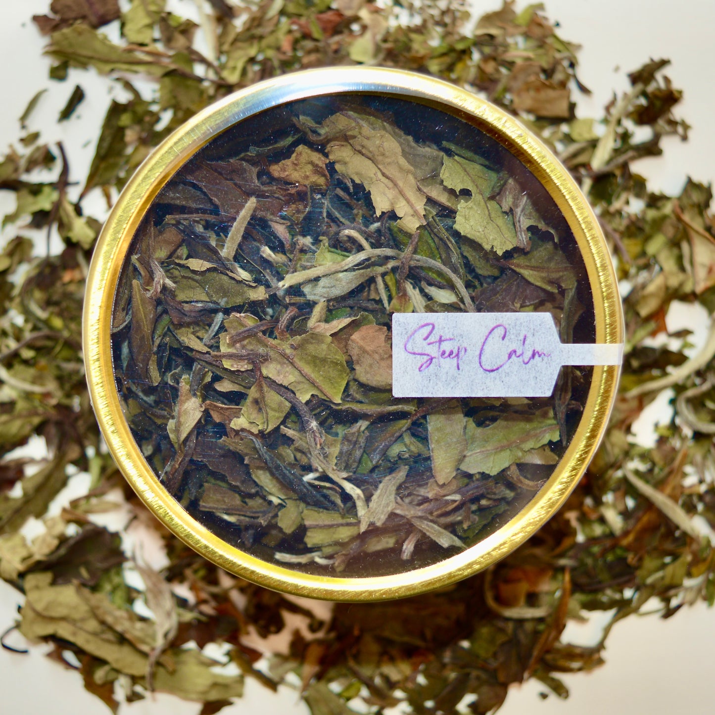 Bai Mu Dan top view White Tea 30 cups of tea size gold finish tin sitting on loose leaf tea that contains Chinese White Tea