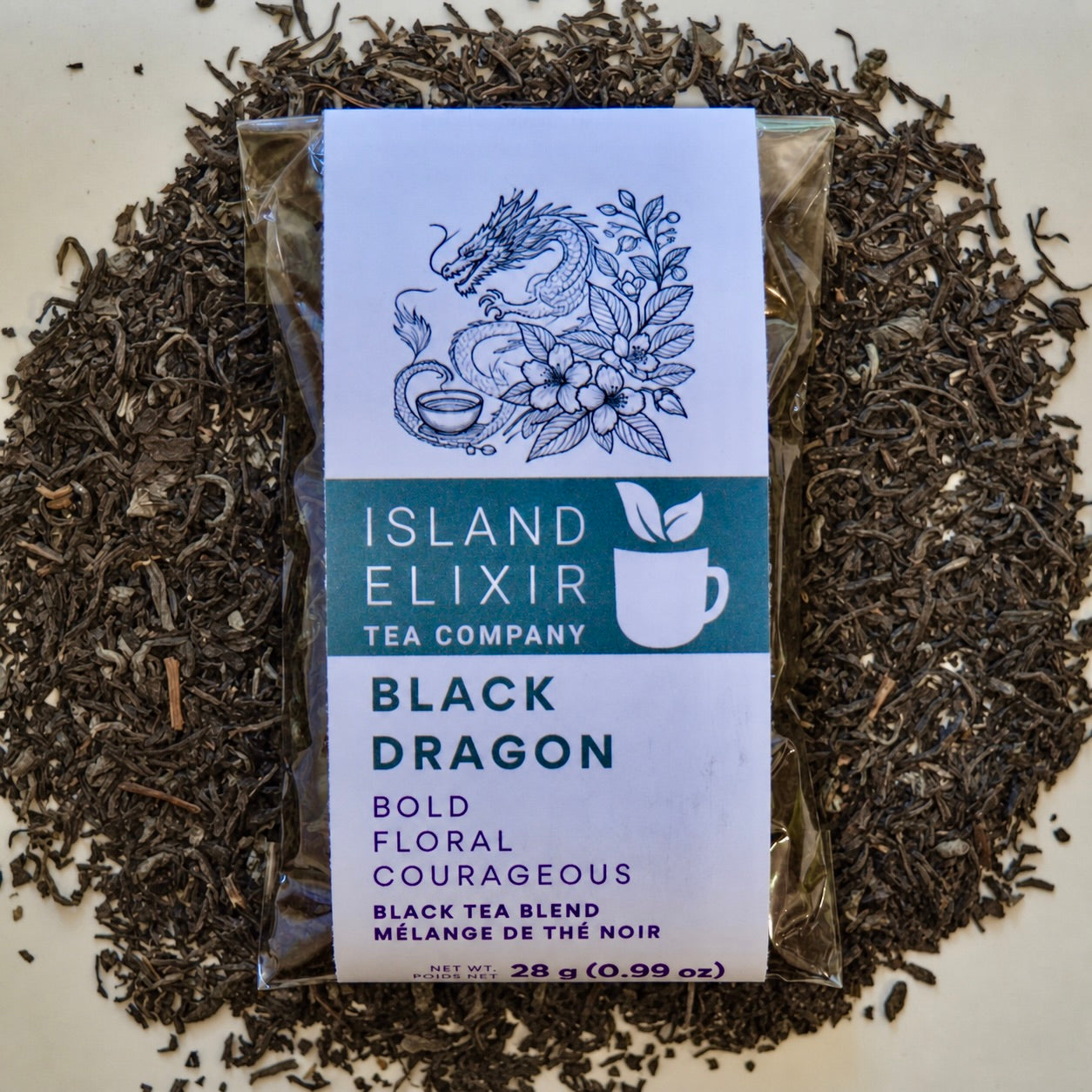 Black Dragon Black Tea 10 cups of tea size compostable packaging sitting on loose leaf tea that contains black tea with jasmine scented green tea