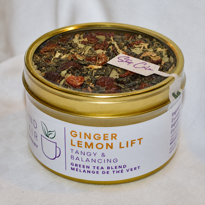 Ginger Lemon Lift Herbal Tea 30 cups of tea size gold finish tin sitting on loose leaf tea that contains Green tea*, rose hip*, eucalyptus*, lemon*, ginger*.