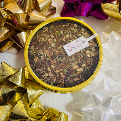 Gold tin of loose leaf tea with decorative bows in the background