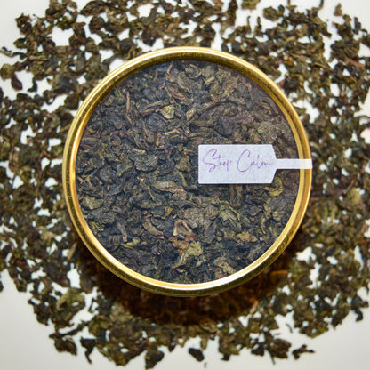 Golden Ember black Tea 30 cups of tea size gold finish tin sitting on loose leaf tea that contains Lightly oxidized oolong tea from China