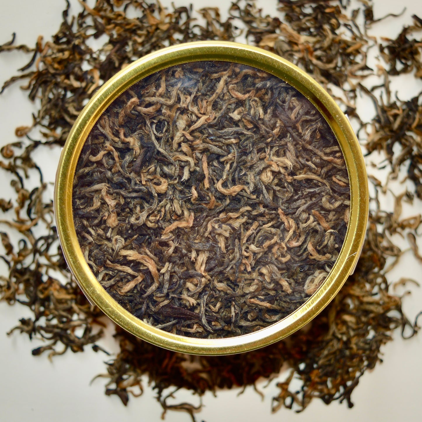 Golden Hour top view Black Tea 30 cups of tea size gold finish tin sitting on loose leaf tea that contains Nepalese black tea (Certified organic)