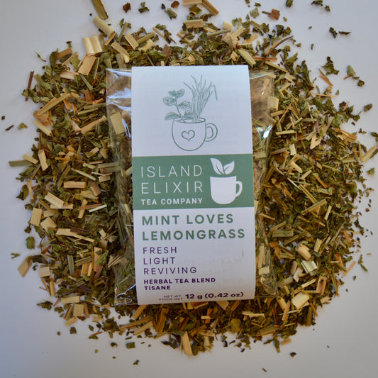 Mint loves lemongrass Herbal Tea 10 cups of tea size compostable packaging sitting on loose leaf tea that contains Lemongrass, peppermint, spearmint, lemon verbena