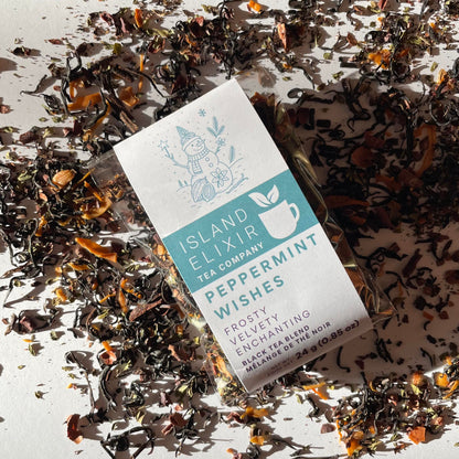 Peppermint Wishes Black Tea Blend 10 cups of tea size surrounded by scattered tea leaves on a white background.