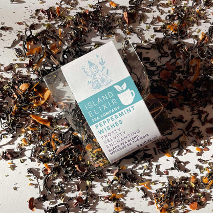 Peppermint Wishes Black Tea Blend 4 cups of tea size lay on scattered tea leaves.