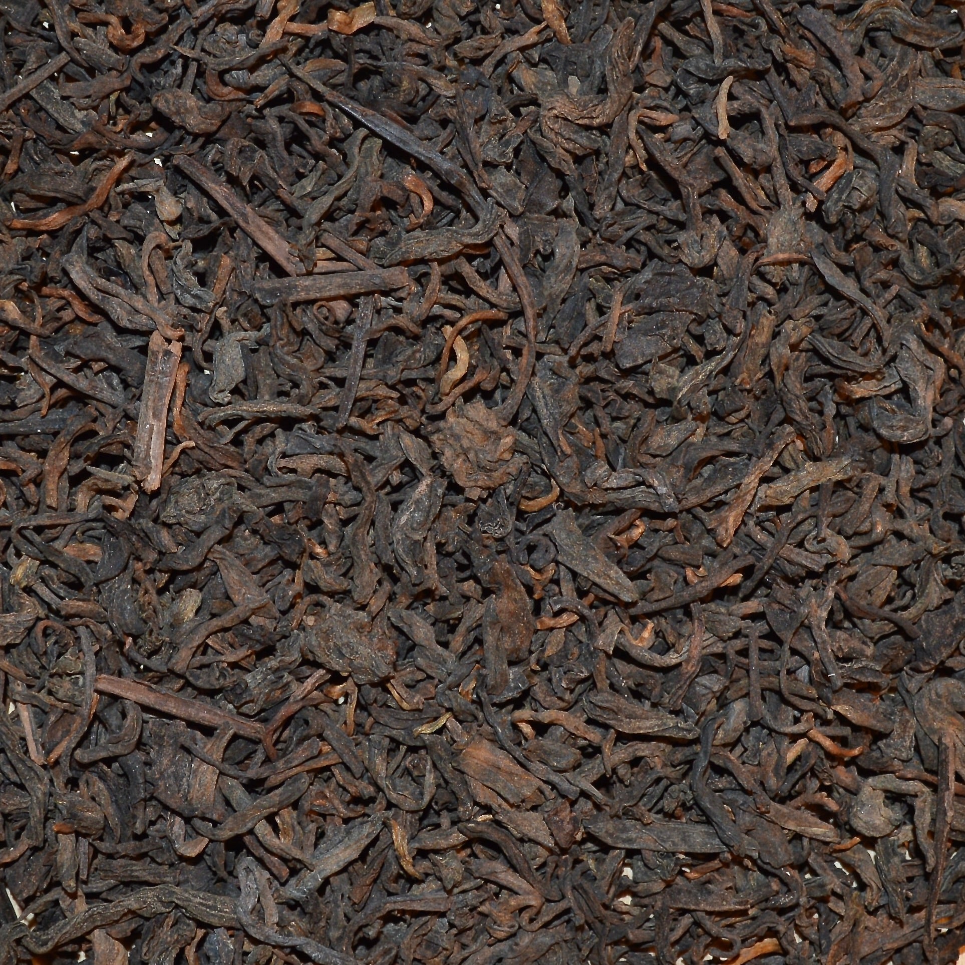 Pu'erh Junior year dried tea leaves close up rich browns and caramel colours