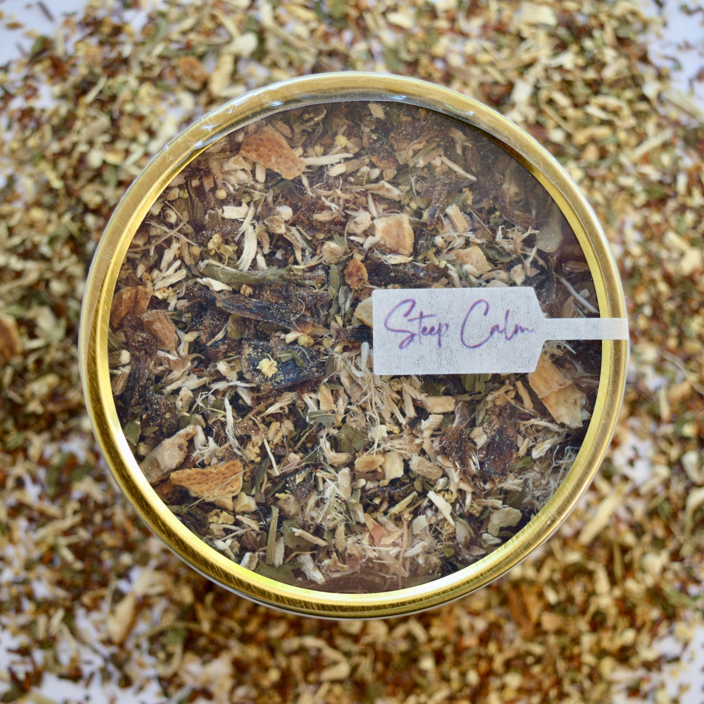 Rooibos Soother Herbal Tea 30 cups of tea size gold finish tin sitting on loose leaf tea that contains Marshmallow root, lemon, rooibos, elderflower, peppermint