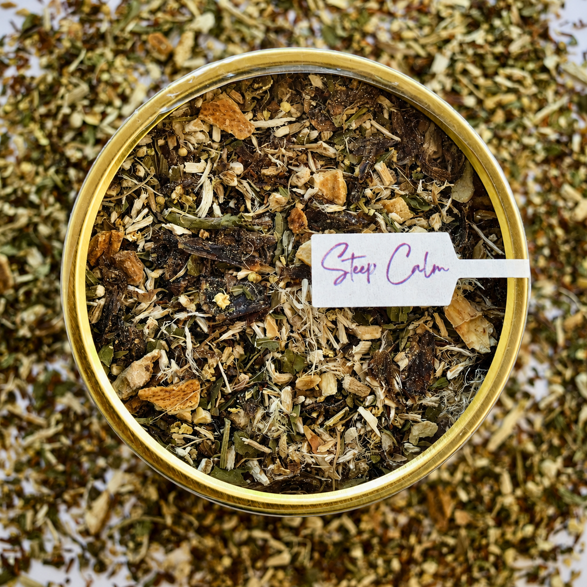 Rooibos Soother Herbal Tea top view 30 cups of tea size gold finish tin sitting on loose leaf tea that contains Marshmallow root, lemon, rooibos, elderflower, peppermint