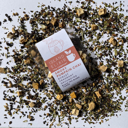 Island Elixir Smoky Pumpkin Chai tea 'Discover' size package surrounded by loose tea leaves on a white background