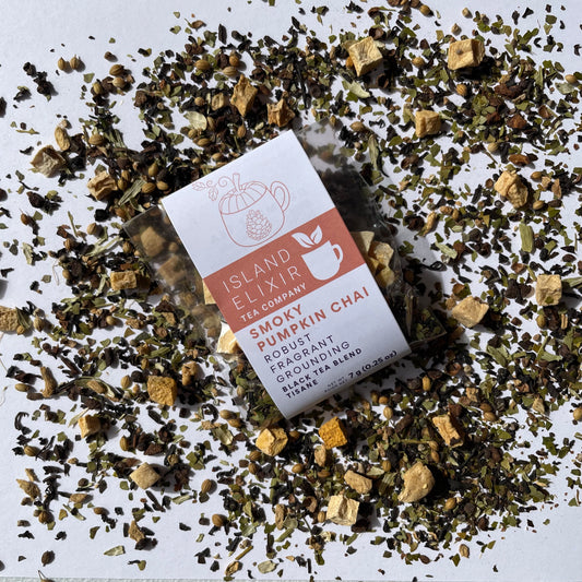 Island Elixir Smoky Pumpkin Chai tea 'Discover' size package surrounded by loose tea leaves on a white background