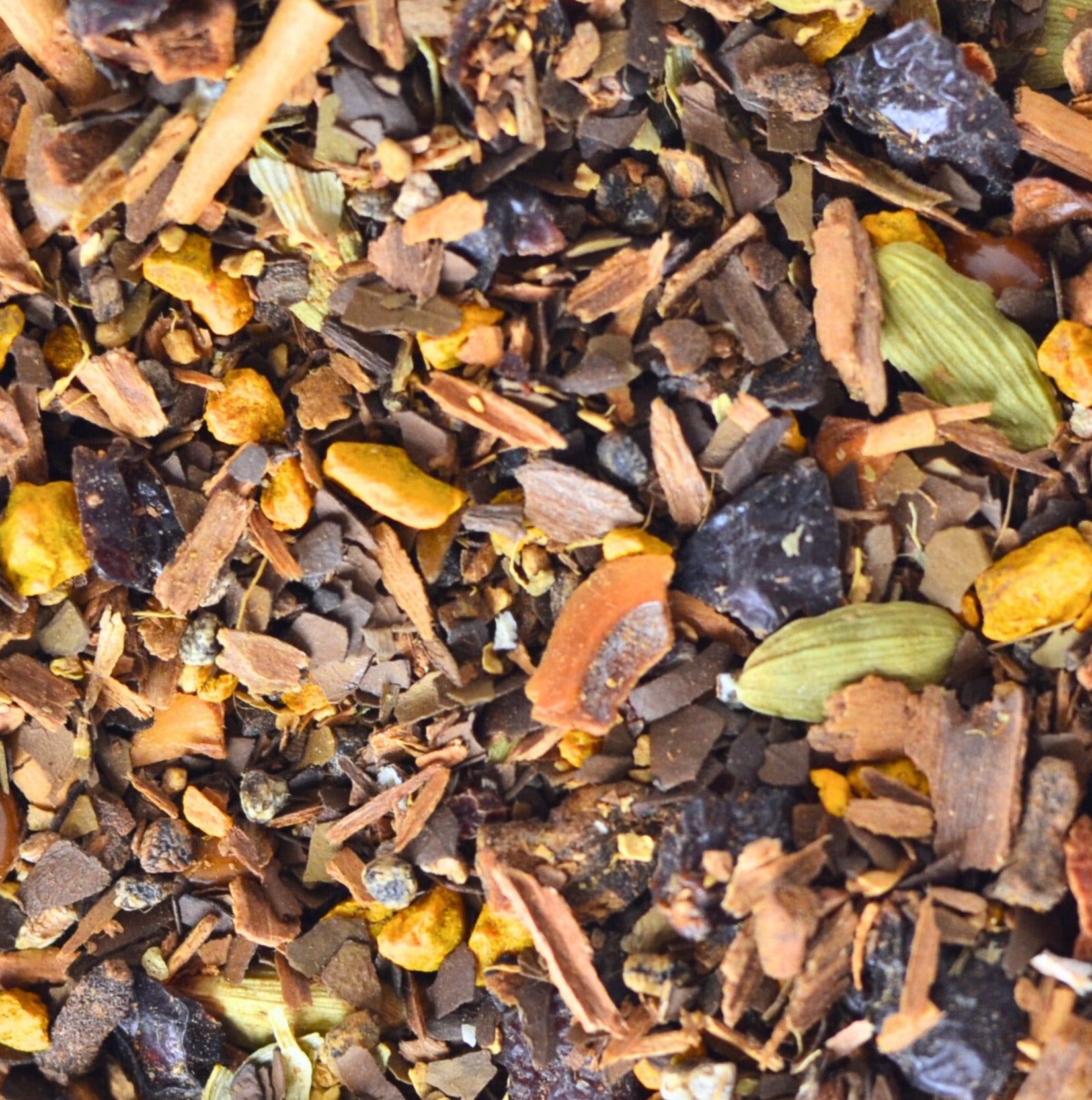 Sumitra's Chai Tea Loose Leaf. A sweet and nutty twist on a classic masala chai (spiced tea). The image shows loose tea up close composed of roasted mate, cinnamon, cardamom, rose hips, ginger, turmeric, star anise.