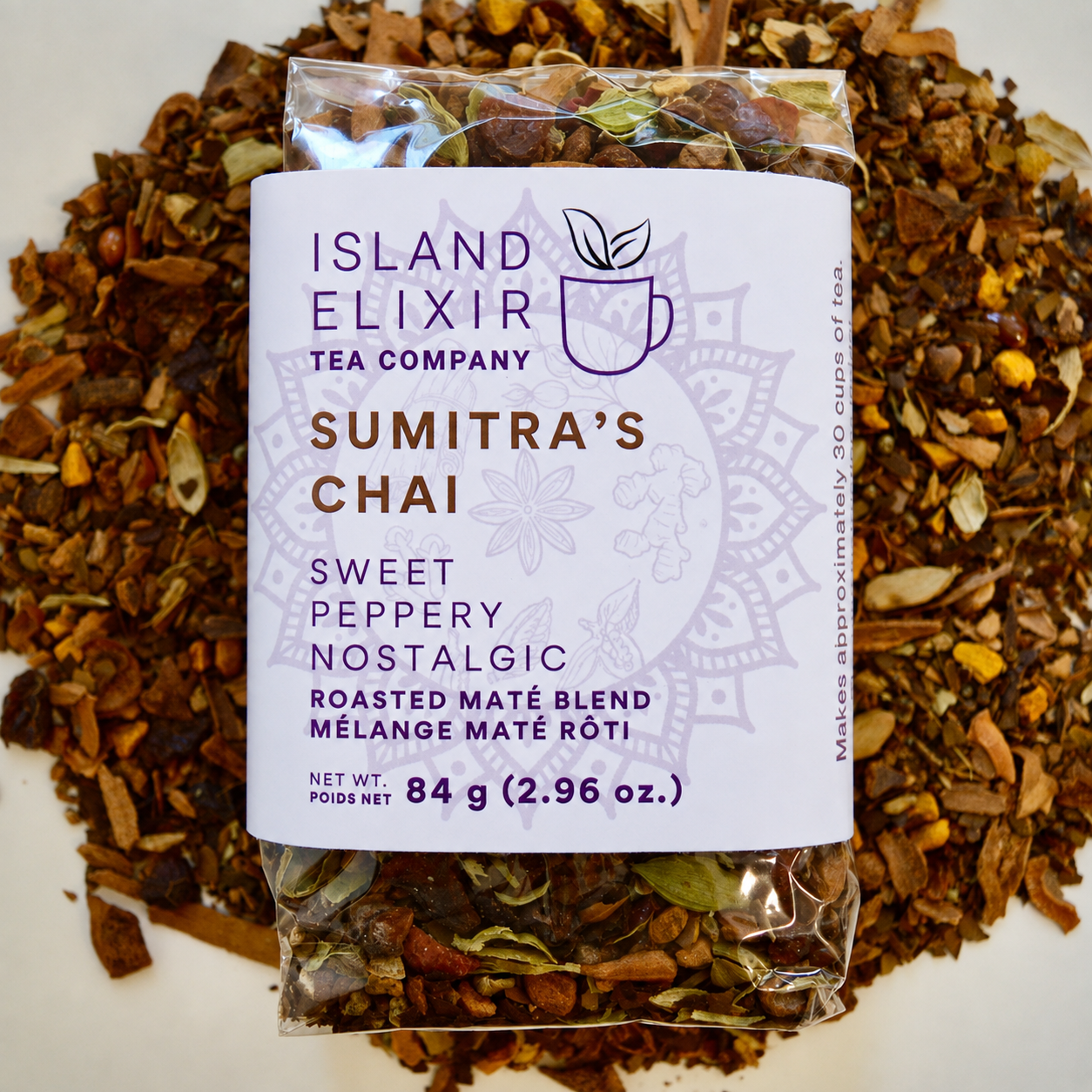 Sumitra's Chai Herbal Tea 30 cups of tea size compostable packaging sitting on loose leaf tea that contains Cinnamon*, Cardamom*, Rose hip*, Star anise*, Turmeric*, Roasted maté*, Clove*, Ginger*.