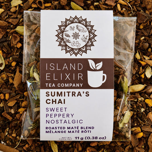 Sumitra's Chai Herbal Tea 4 cups of tea size compostable packaging sitting on loose leaf tea that contains Cinnamon*, Cardamom*, Rose hip*, Star anise*, Turmeric*, Roasted maté*, Clove*, Ginger*.
