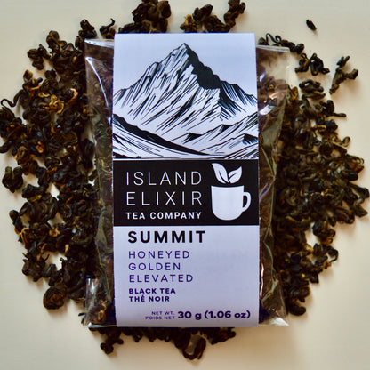 Summit Black Tea 10 cups of tea size compostable packaging sitting on loose leaf tea that contains Nepalese black tea
