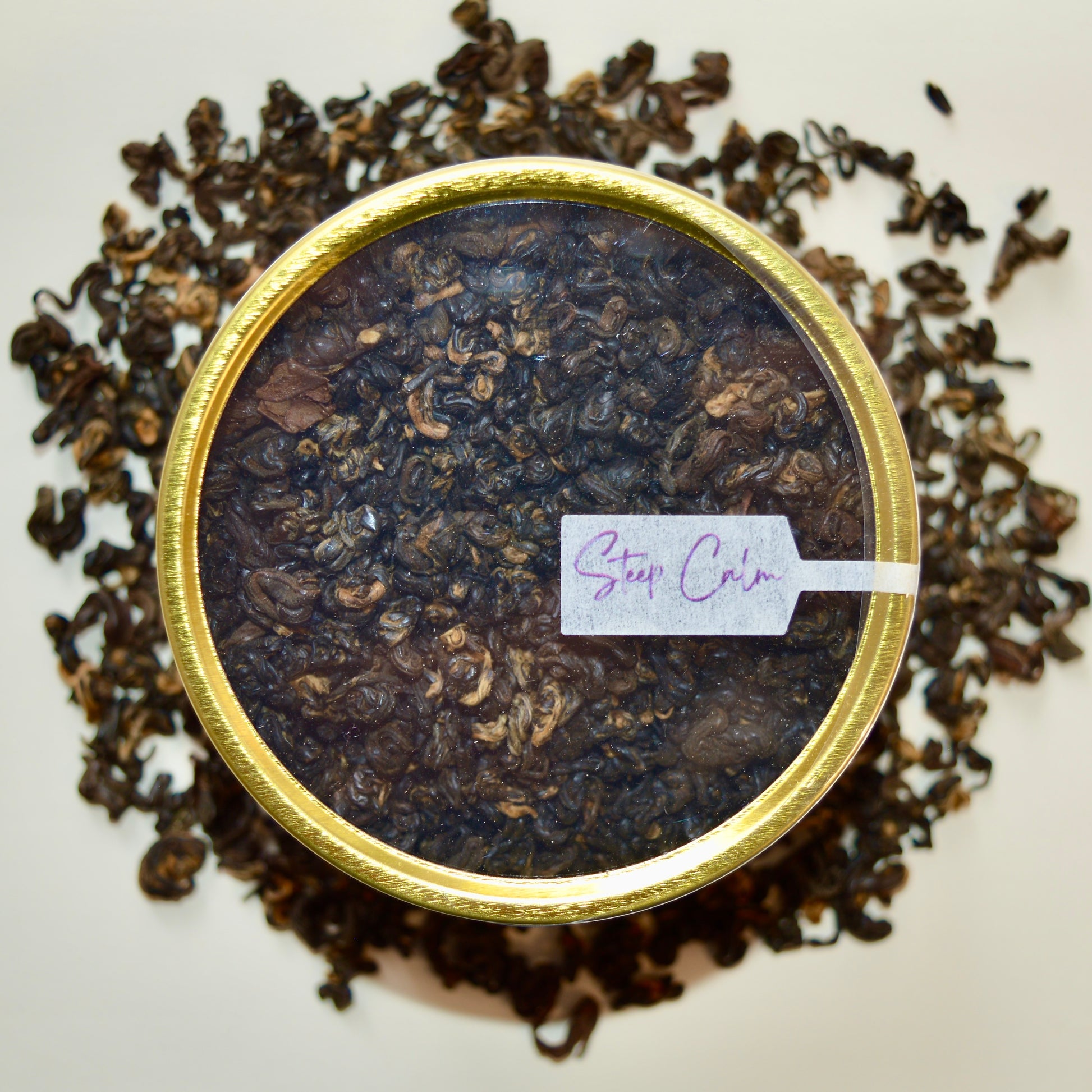 Summit Top view Black Tea 30 cups of tea size gold finish tin sitting on loose leaf tea that contains Nepalese black tea