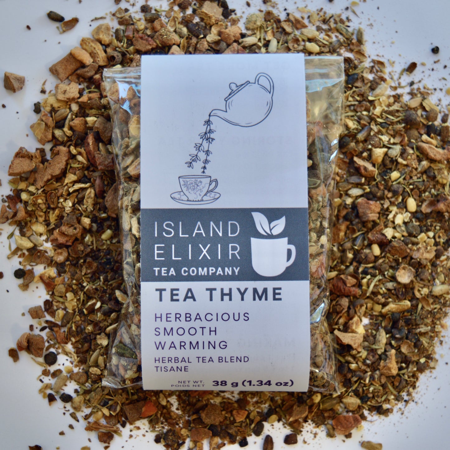 Tea Thyme Herbal Tea 10 cups of tea size compostable packaging sitting on loose leaf tea that contains Allspice, milk thistle seed, apple, ginger, grapefruit, thyme.