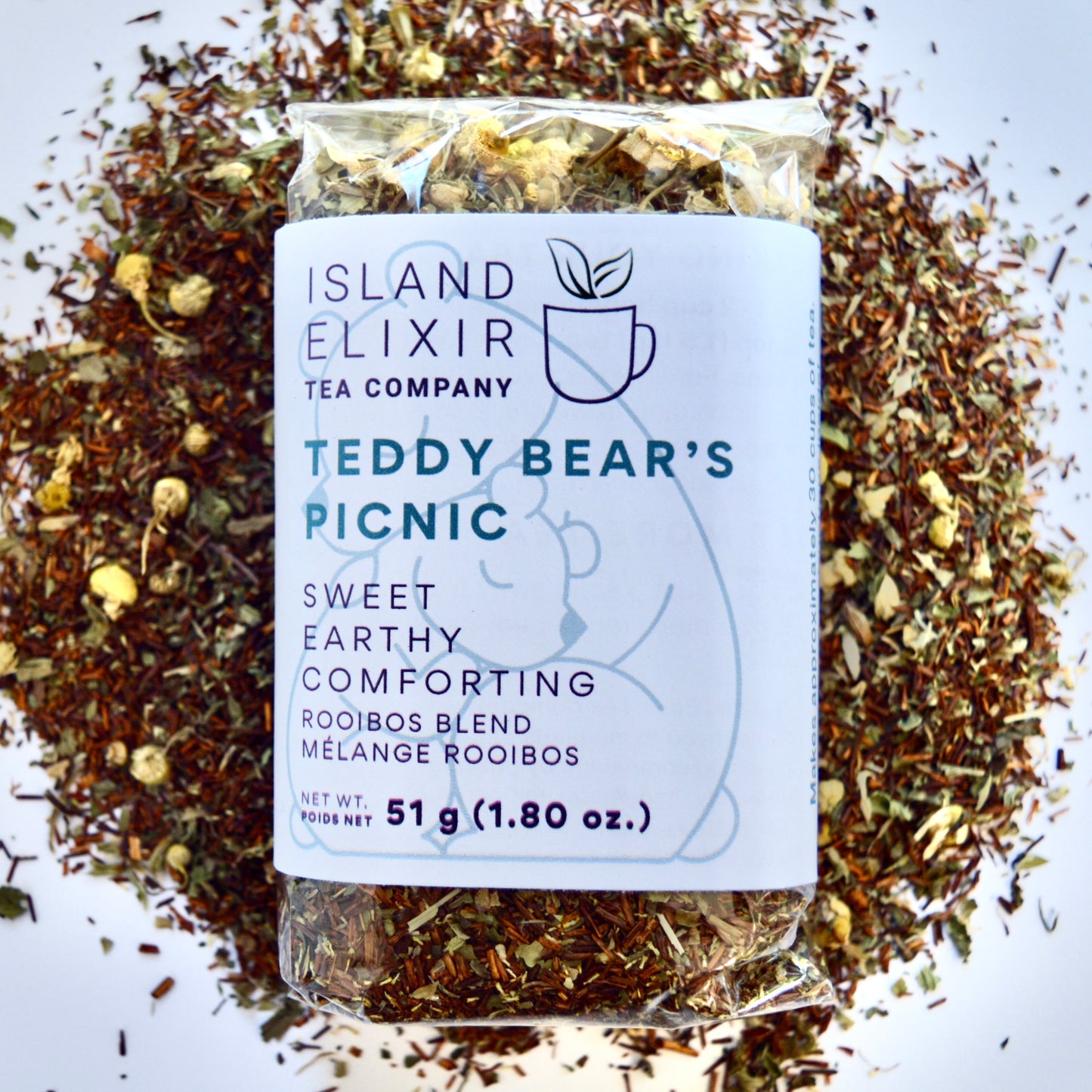 Teddy bear picnic Herbal Tea 30 cups of tea size compostable packaging sitting on loose leaf tea that contains Rooibos, lemon balm, peppermint, chamomile
