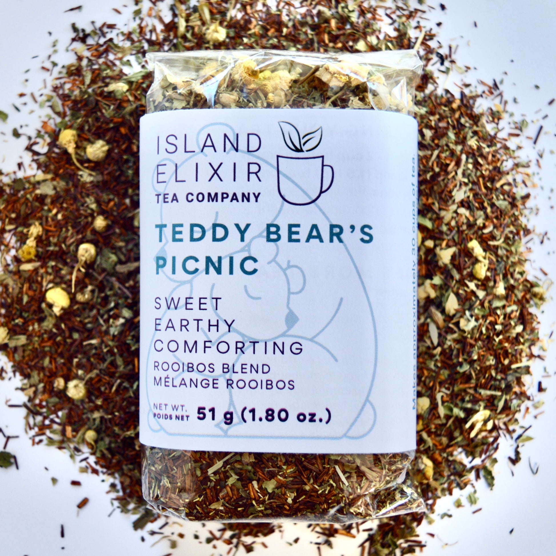 Teddy bear picnic Herbal Tea 30 cups of tea size compostable packaging sitting on loose leaf tea that contains Rooibos, lemon balm, peppermint, chamomile