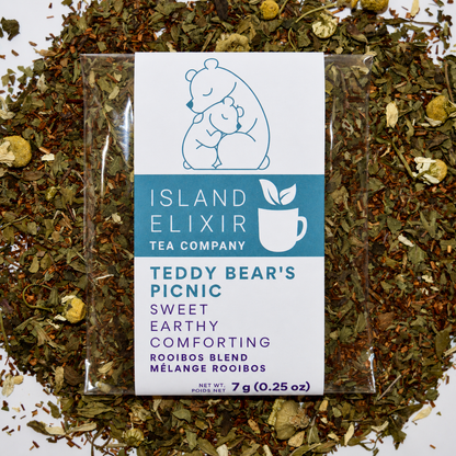 Teddy bear picnic Herbal Tea 4 cups of tea size compostable packaging sitting on loose leaf tea that contains Rooibos*, lemon balm*, peppermint*, chamomile*.