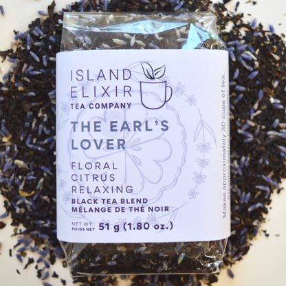 The Earl's Lover Black Tea 30 cups of tea size compostable packaging sitting on loose leaf tea that contains Black tea*, lavender**, anise hyssop*, bergamot flavour (organic compliant) 

