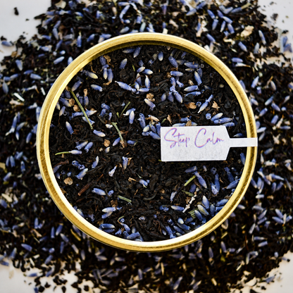 The Earl's Lover Black Tea 30 cups of tea size gold finish tin sitting on loose leaf tea that contains Black tea*, lavender**, anise hyssop*, bergamot flavour (organic compliant) 

