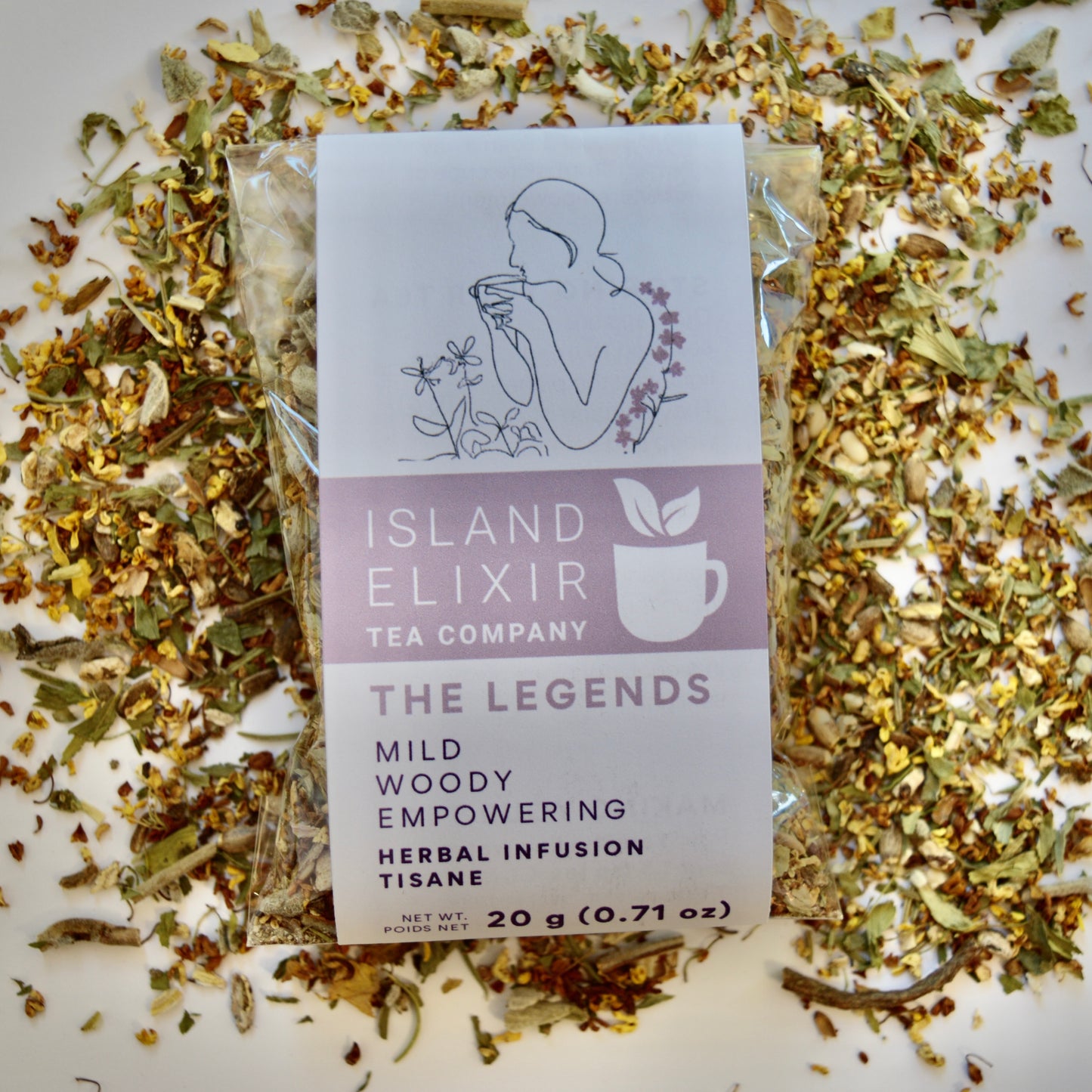 The Legends Herbal Tea 10 cups of tea size compostable packaging sitting on loose tea that contains Milk thistle seed, Osmanthus, Dandelion root, Alfalfa, Sage, Rosemary.