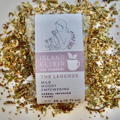 The Legends Herbal Tea 10 cups of tea size compostable packaging sitting on loose tea that contains Milk thistle seed, Osmanthus, Dandelion root, Alfalfa, Sage, Rosemary.
