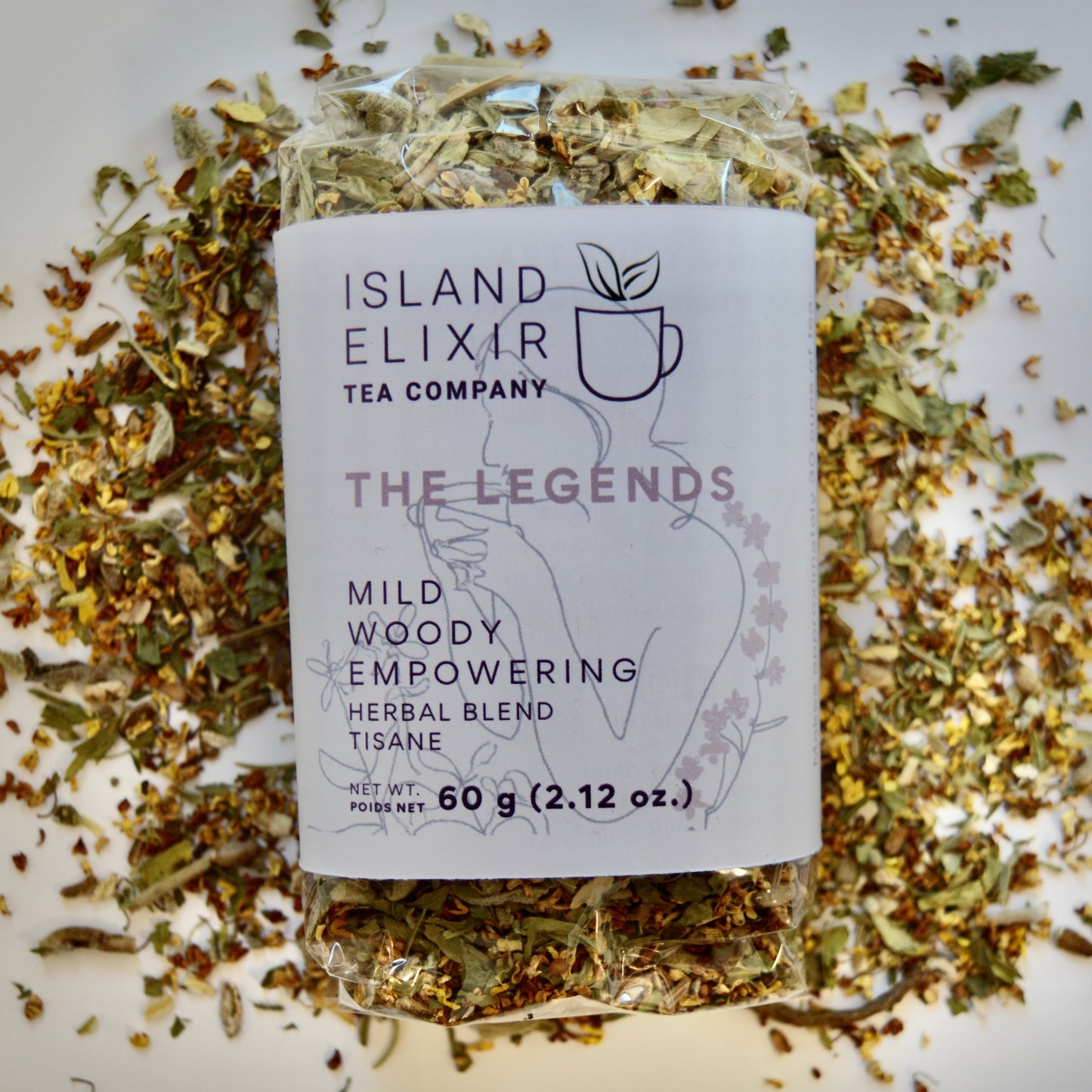 The Legends Herbal Tea 30 cups of tea size compostable packaging sitting on loose tea that contains Milk thistle seed, Osmanthus, Dandelion root, Alfalfa, Sage, Rosemary.