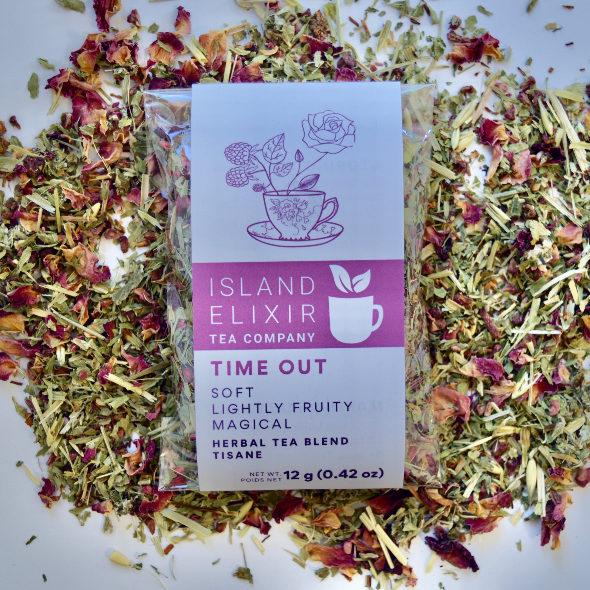 Time out Herbal Tea 10 cups of tea size compostable packaging sitting on loose leaf tea that contains Raspberry, Alfalfa, Oatstraw, Rose, Rooibos, Nettle, Red clover, Raspberry leaf