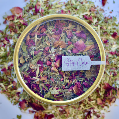 Time out Herbal Tea 30 cups of tea size gold finish tin sitting on loose leaf tea that contains Raspberry, Alfalfa, Oatstraw, Rose, Rooibos, Nettle, Red clover, Raspberry leaf
