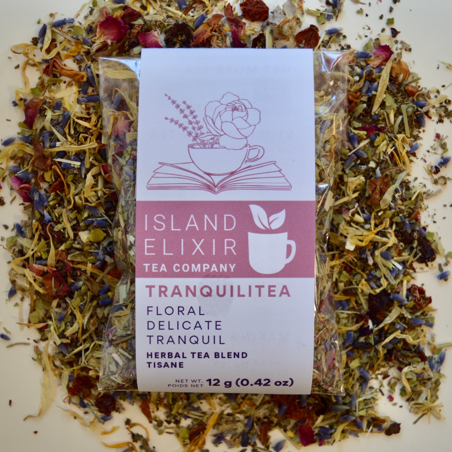 Tranquilitea Herbal Tea 10 cups of tea size compostable packaging sitting on loose leaf tea that contains Rose hip*, Lemon balm*, Lavender**, Oatstraw*, Marshmallow leaf*, Calendula*, Rose petals*.