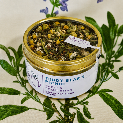 teddy bear picnic Herbal Tea 15 cups of tea size gold finish tin sitting on loose leaf tea that contains Rooibos, lemon balm, peppermint, chamomile